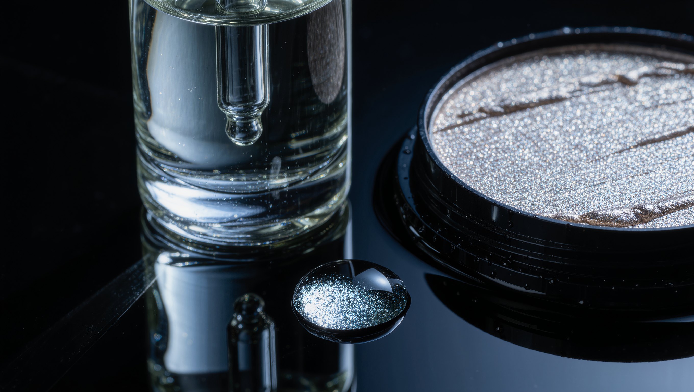 Schimmernde Highlighter-Textur auf einem Spatel vor dunklem Hintergrund, Glanzlichter auf feuchter Oberflaeche